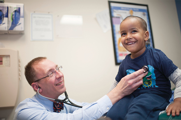 Doctor listening to kids heart with a stethoscope