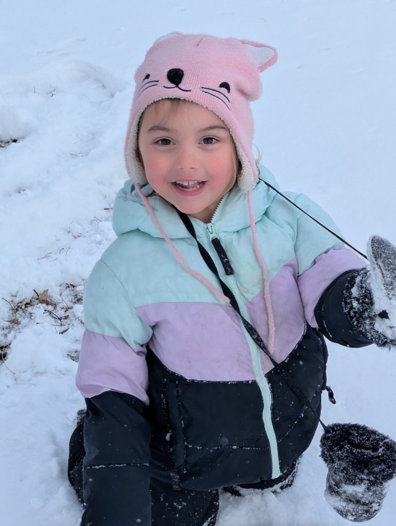 Chloe in her winter gear outside in the snow