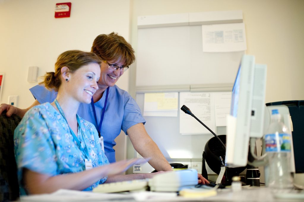 Radiologic technologists looking at a scan on a computer screen