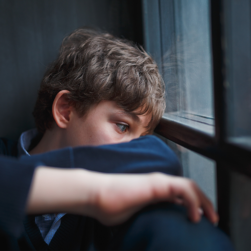 Sad teen boy staring out the window