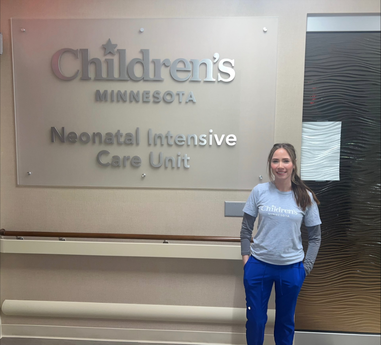 Sammy in front of a Children's Minesota NICU sign.