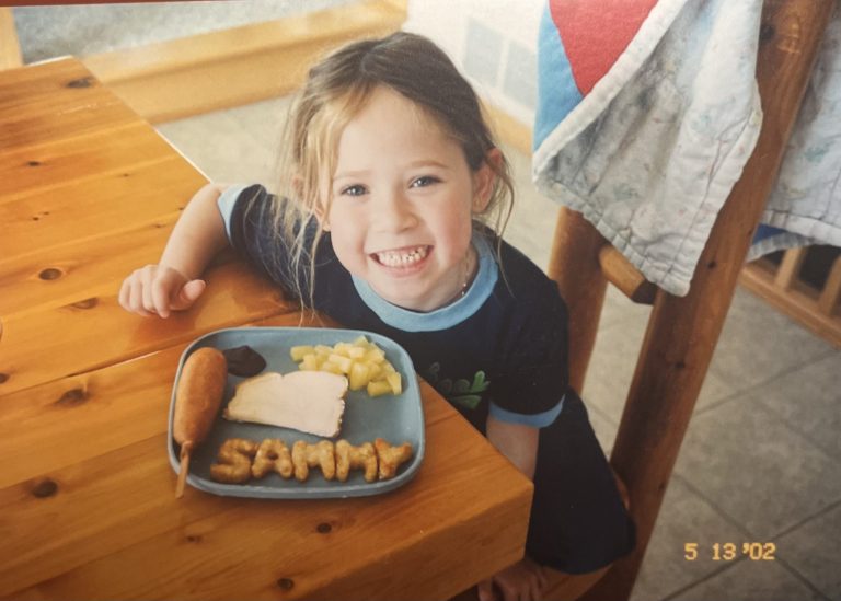 Sammy smiling and eating lunch.