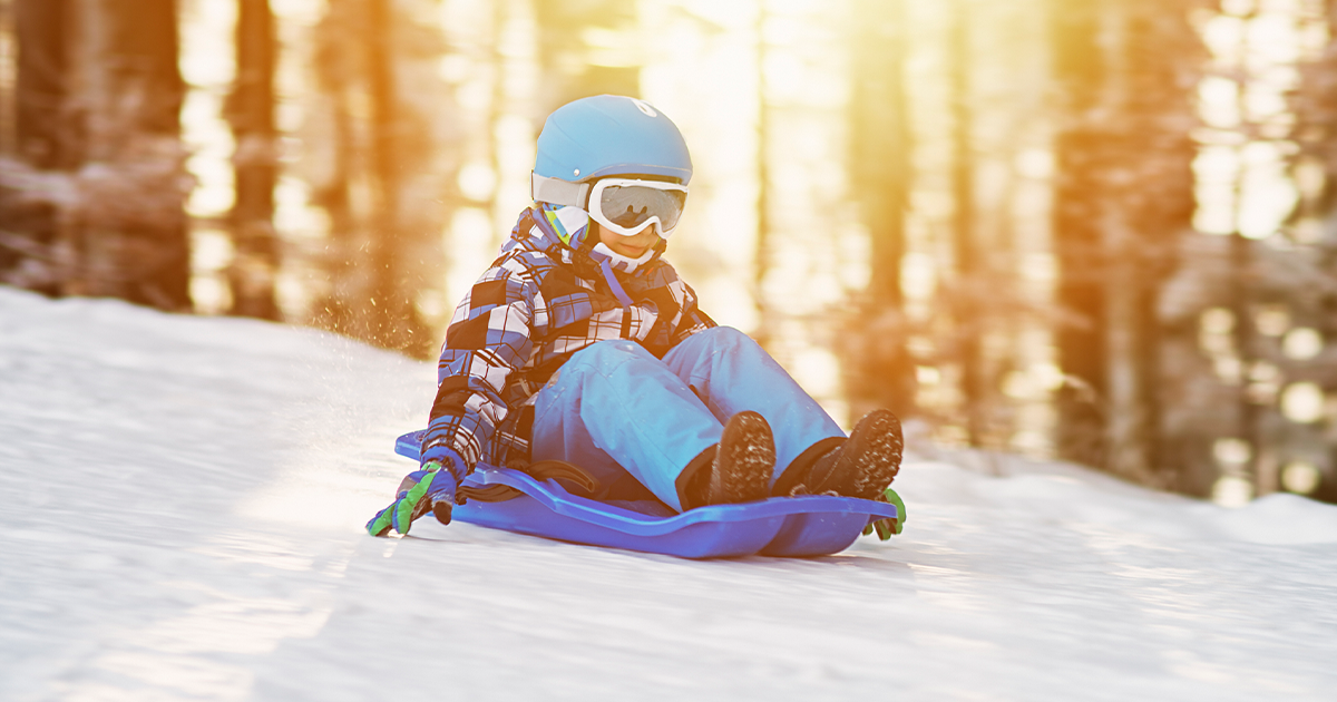 6-year-old-boy in blue helmet sledding