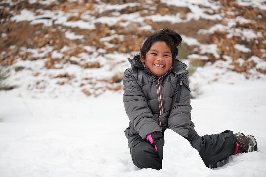 child playing in the snow
