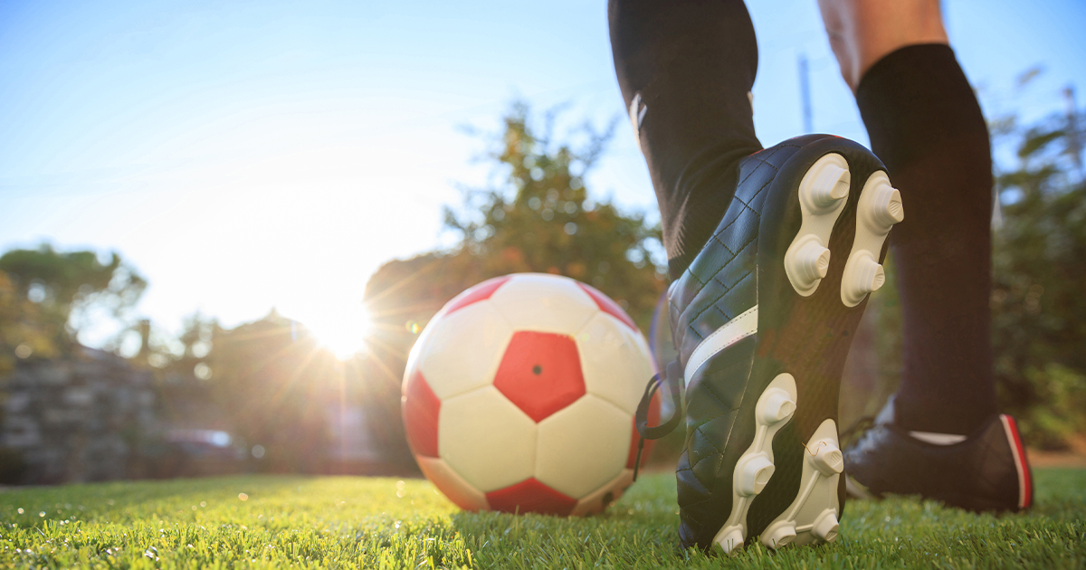 teenage girl playing soccer outside