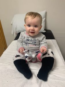 Baby Stella sits on a hospital bed