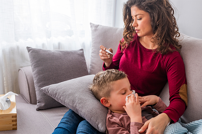 a mom takes a boy's temperature