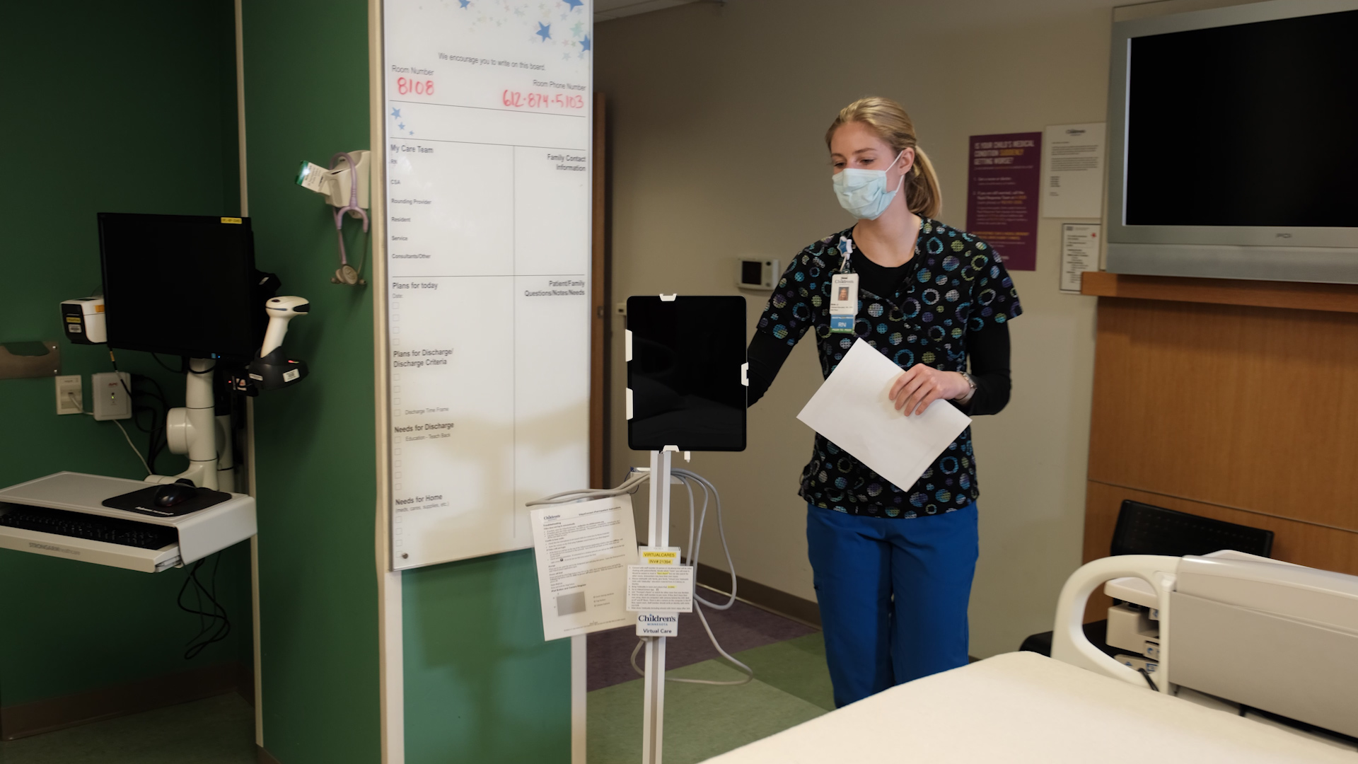 A nurse uses a telebuddy in a hospital room.