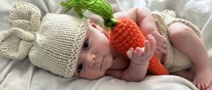 Owen today with an infant outfit on holding a carrot