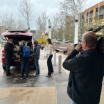Getting box of backpacks out from trunk of car