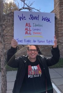 Alissa holding a sign supporting LGBTQ+ community