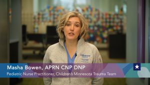 A woman with medium length blonde hair is speaking to the camera. At the bottom of the screen it says: Masha Bowen, APRN CNP DNP Pediatric Nurse Practitioner, Children's Minnesota Trauma Team.