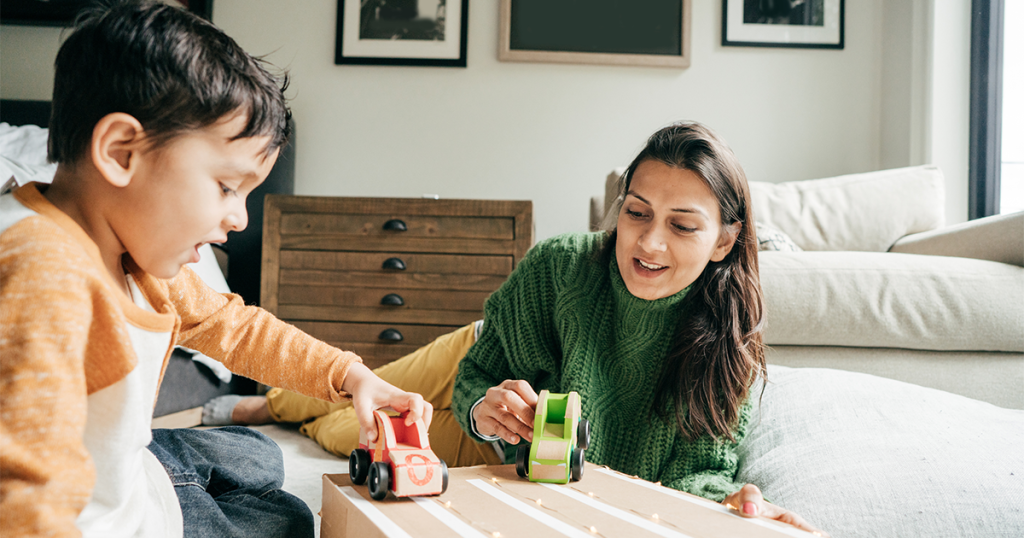 mother and son playing with toy cars at home