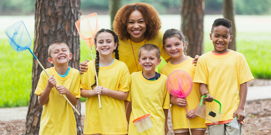 Kids at camp with their camp counselor