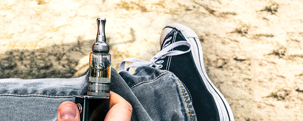 A teen vaping outside