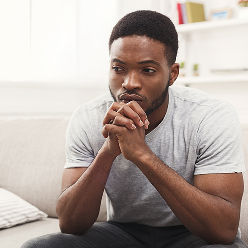 Young black teenager at home thinking
