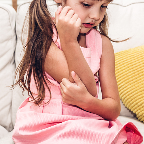Little girl with arm pain on the couch.