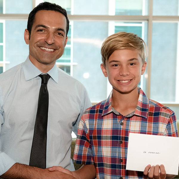 Tate and Dr. Kebriaei shaking hands with Tate's gift
