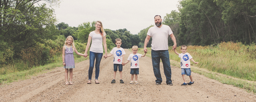 Shelby Herlick's family standing on a dirt road holding hands