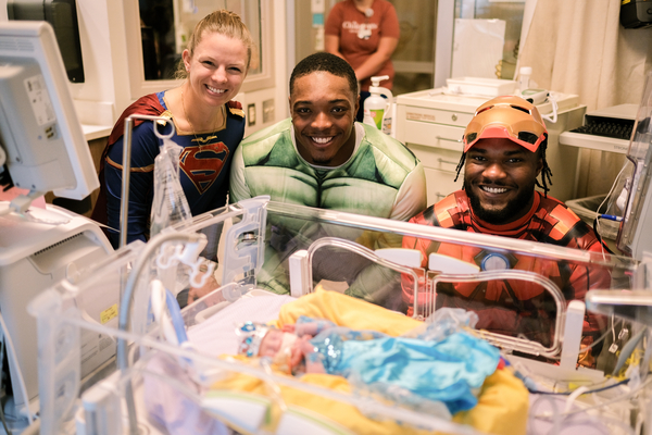 NICU baby dressed up as a princess for Halloween with Vikings players
