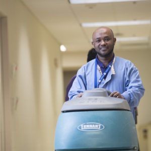 Maintenance worker cleans the floors.