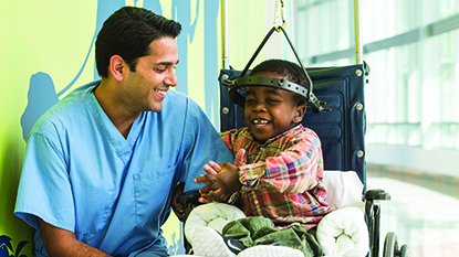 Un médico habla con un niño que tiene un aparato de tracción cervical con halo.